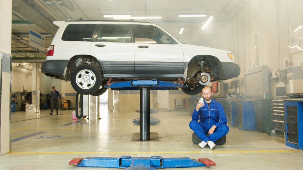 a service man servicing a car that has flat tires